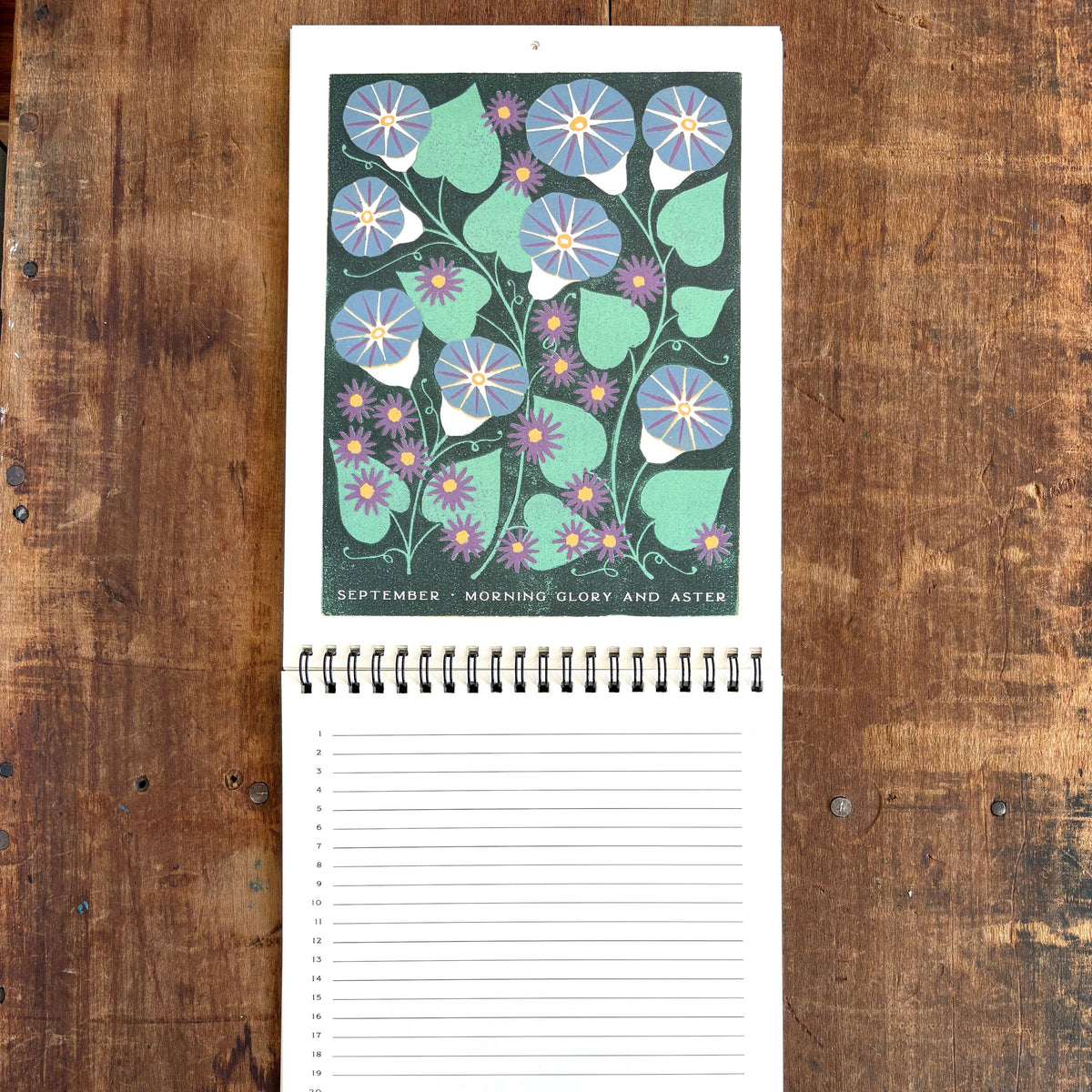 Notebook with floral design on the cover, placed on a wooden surface