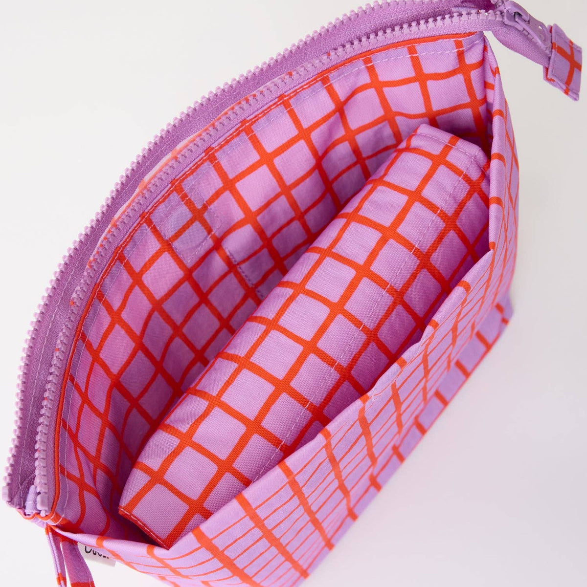 A pink and orange plaid zippered pouch with a matching wrist strap, shown open to reveal an interior organizer pocket containing a matching cylindrical pouch.