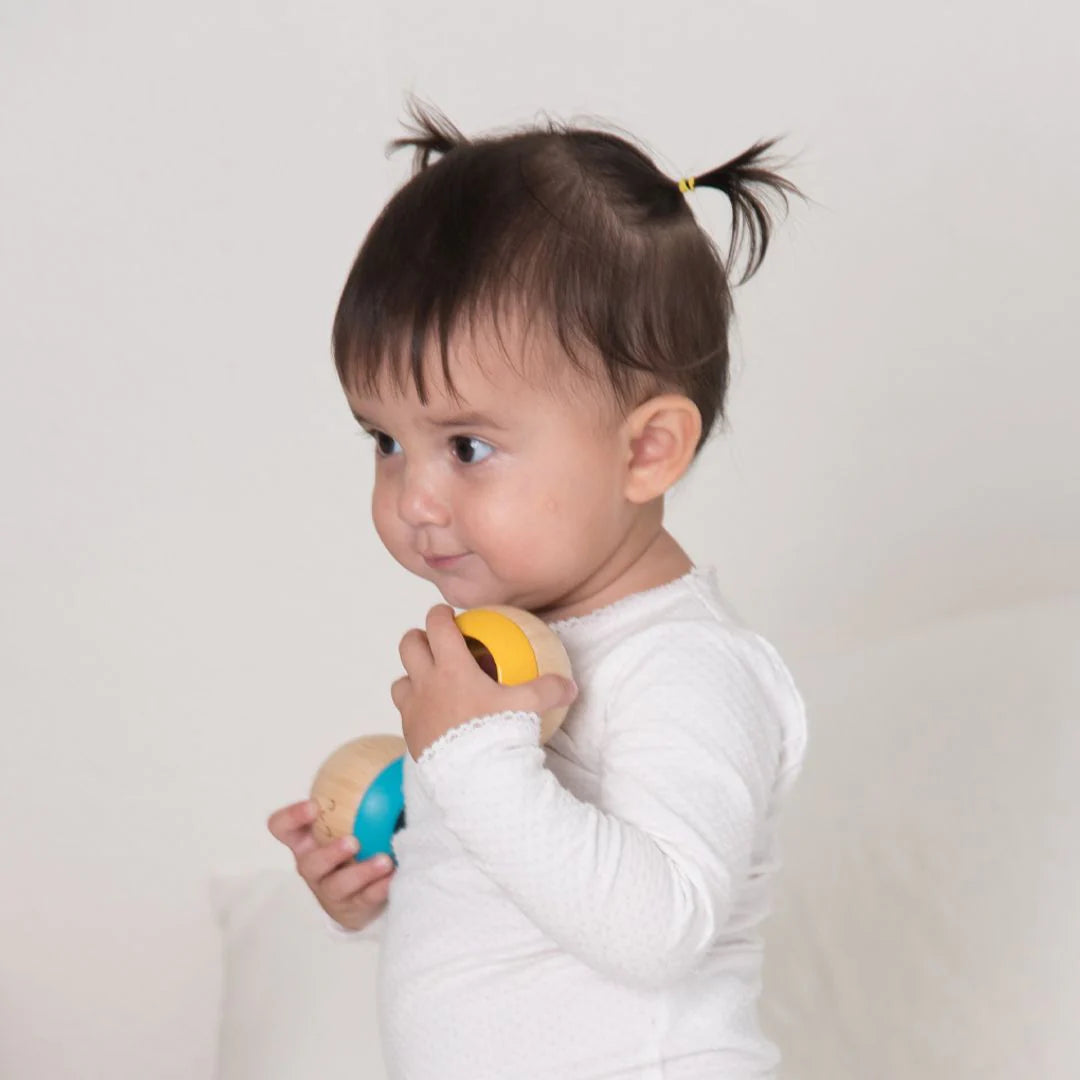 Child holding a colorful toy against a plain background