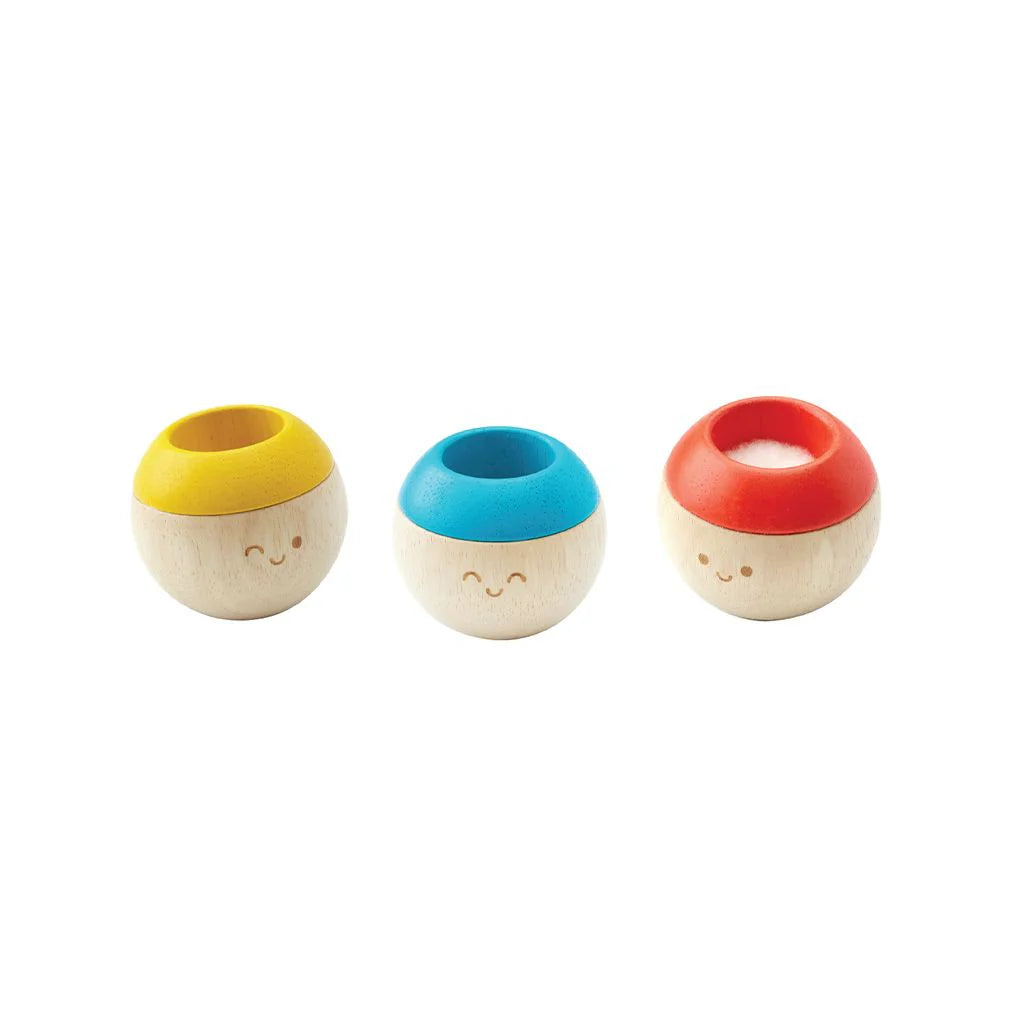 Three small wooden containers with colorful lids on a white background