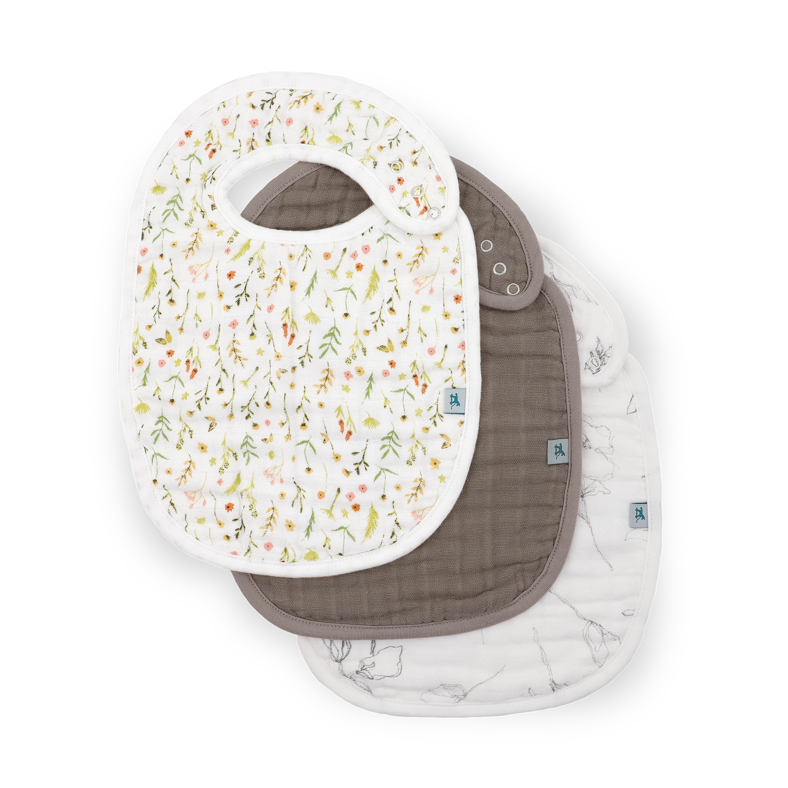 Three reusable baby bibs stacked on a white background. The top bib is white with a delicate multicolor floral and leaf print.