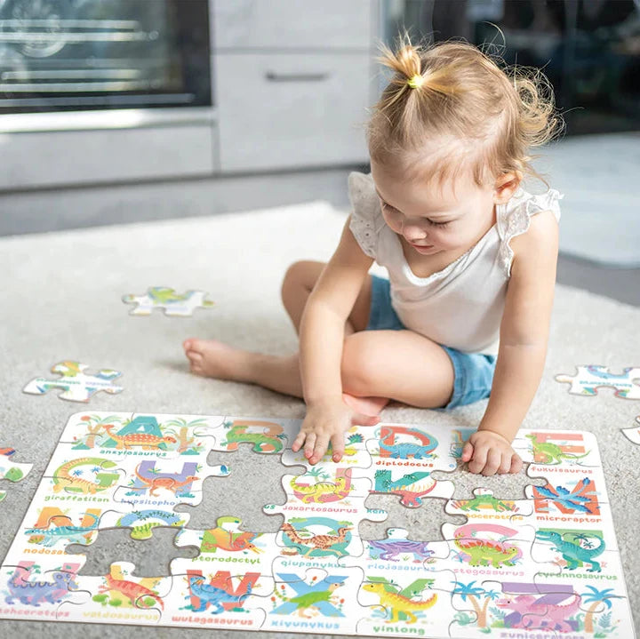 Child playing with a dinosaur puzzle on the floor in a kitchen.