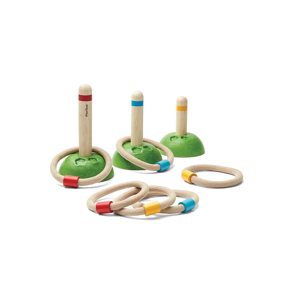 Wooden ring toss game set with green stands and colorful rings on a white background