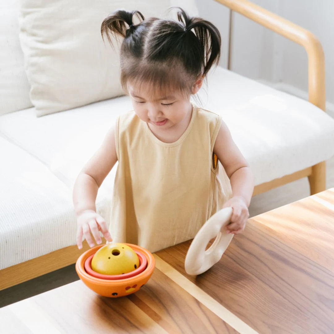 Child playing with colorful toys on a wooden table