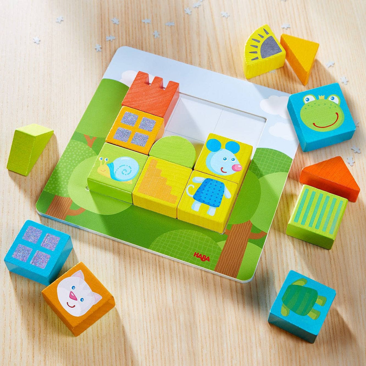 Colorful wooden blocks with animal faces on a matching game board, on a wooden surface.