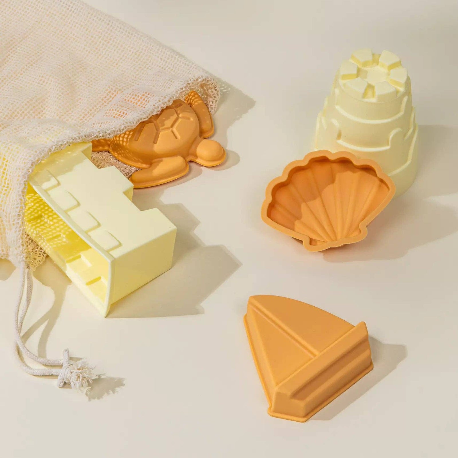 Set of silicone molds shaped like a turtle, shell, sailboat, and house on a light background