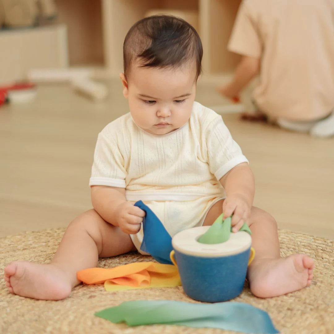 Baby playing with colorful toys on a carpeted floor