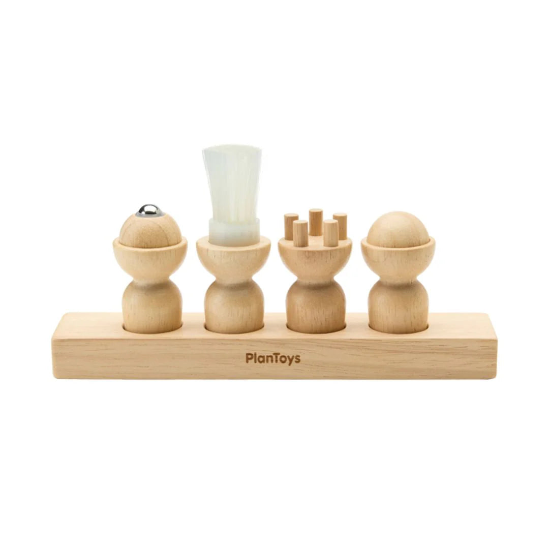 Wooden toy with various shapes and a white cylindrical object on a white background, branded 'PlanToys'.