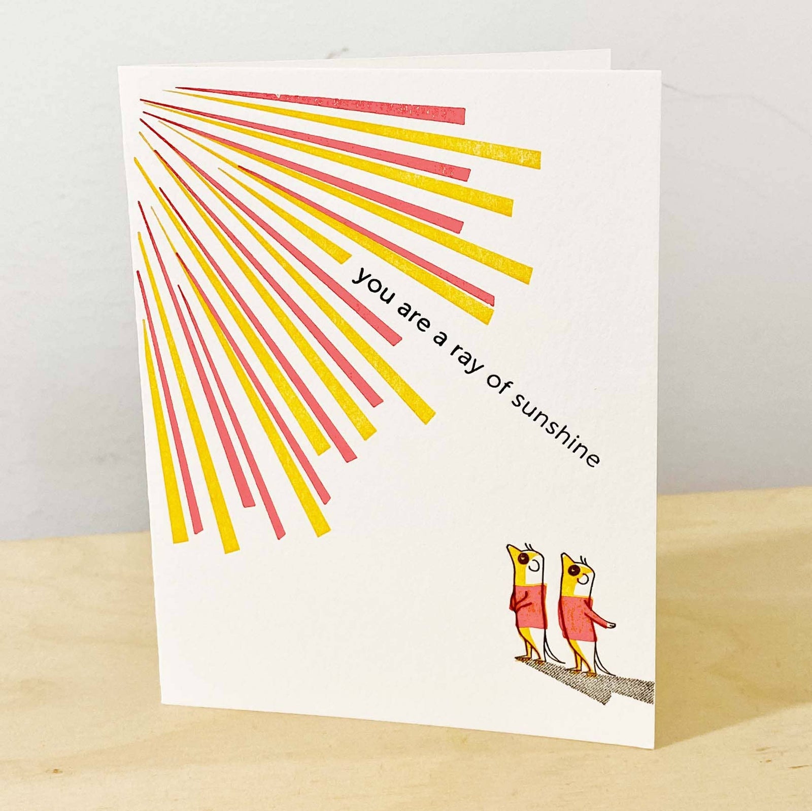 Greeting card with sunburst design and birds on a branch, featuring the text 'you are a ray of sunshine'.