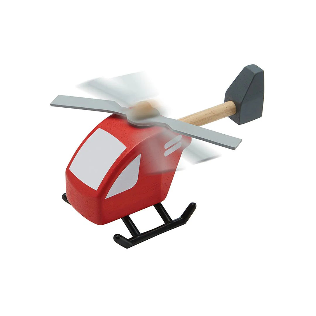 Red toy helicopter with spinning propeller on a white background