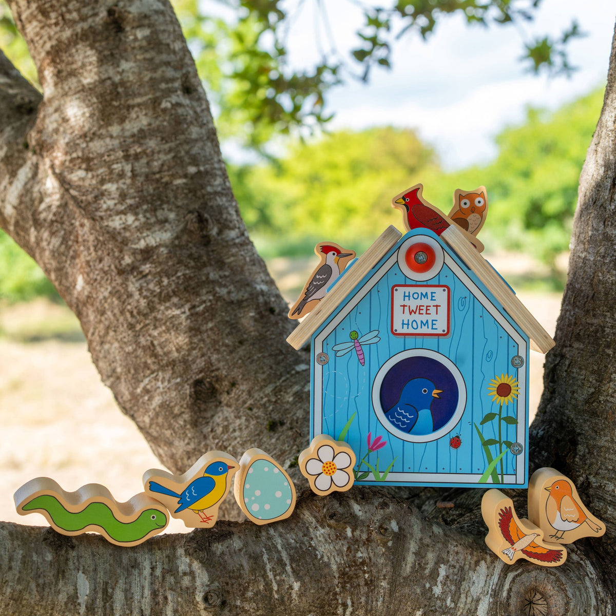 Decorative birdhouse and cookies on a tree branch with a natural background