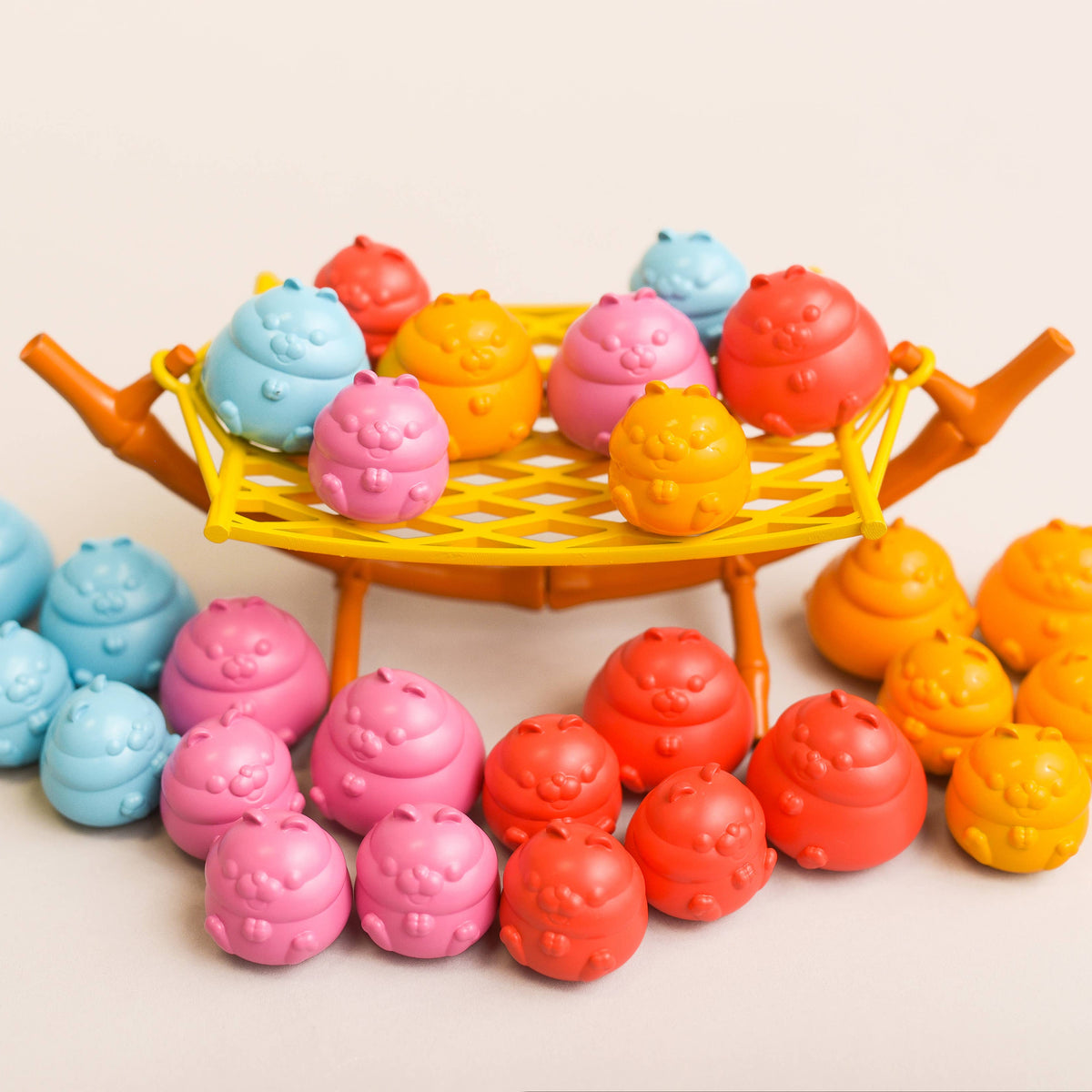 Colorful toys shaped like hamsters on a stand with a plain background