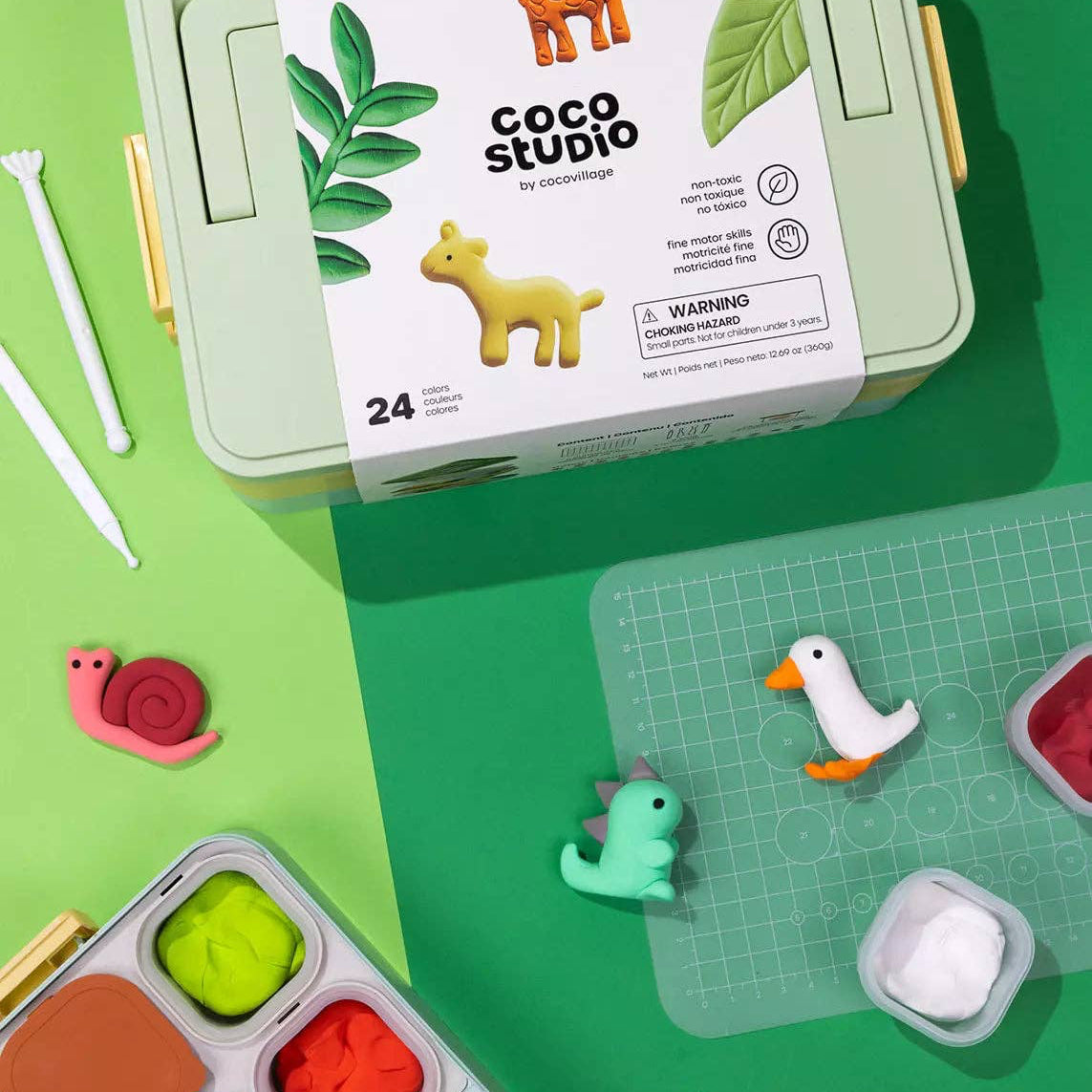 Coco Studio art kit with small figurines on a green background