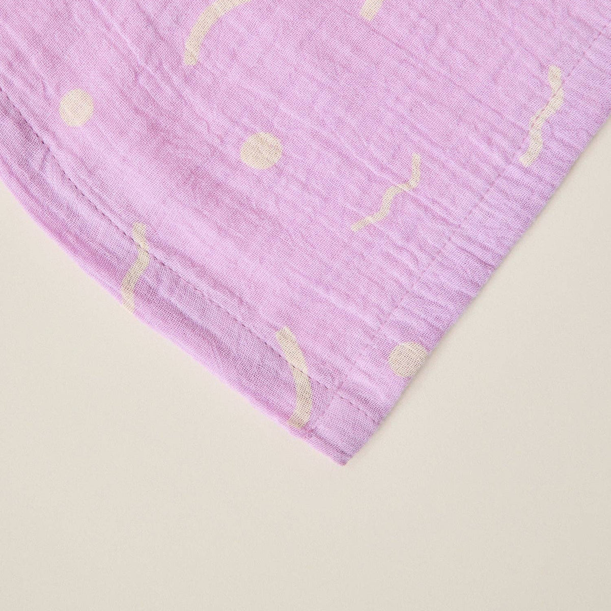 Purple fabric with gold patterns on a beige background