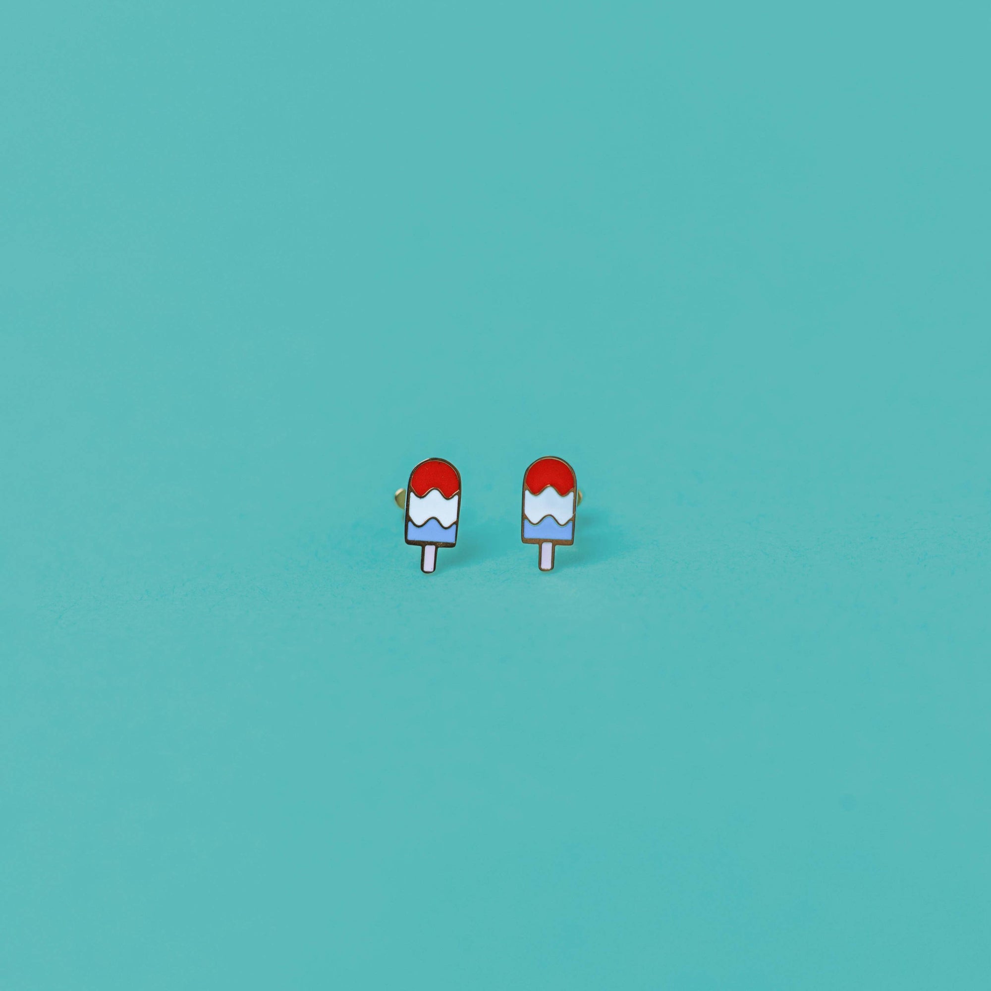 Jankelly earrings packaging on a teal background