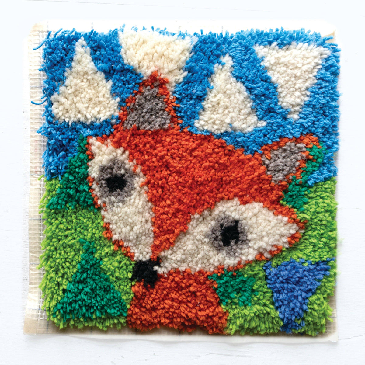 Latch hook rug with a fox design on a white background