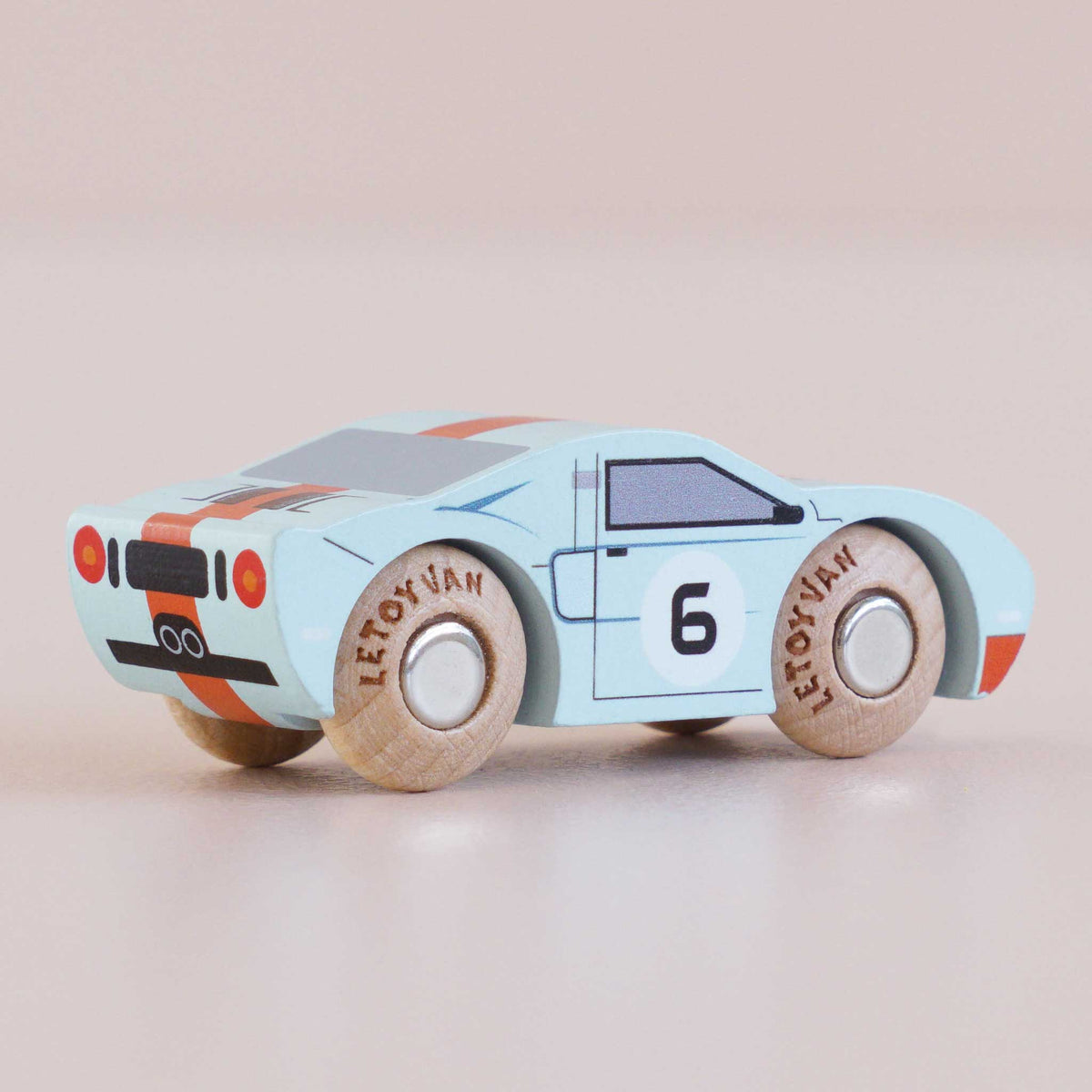 Toy car with wooden wheels on a beige background