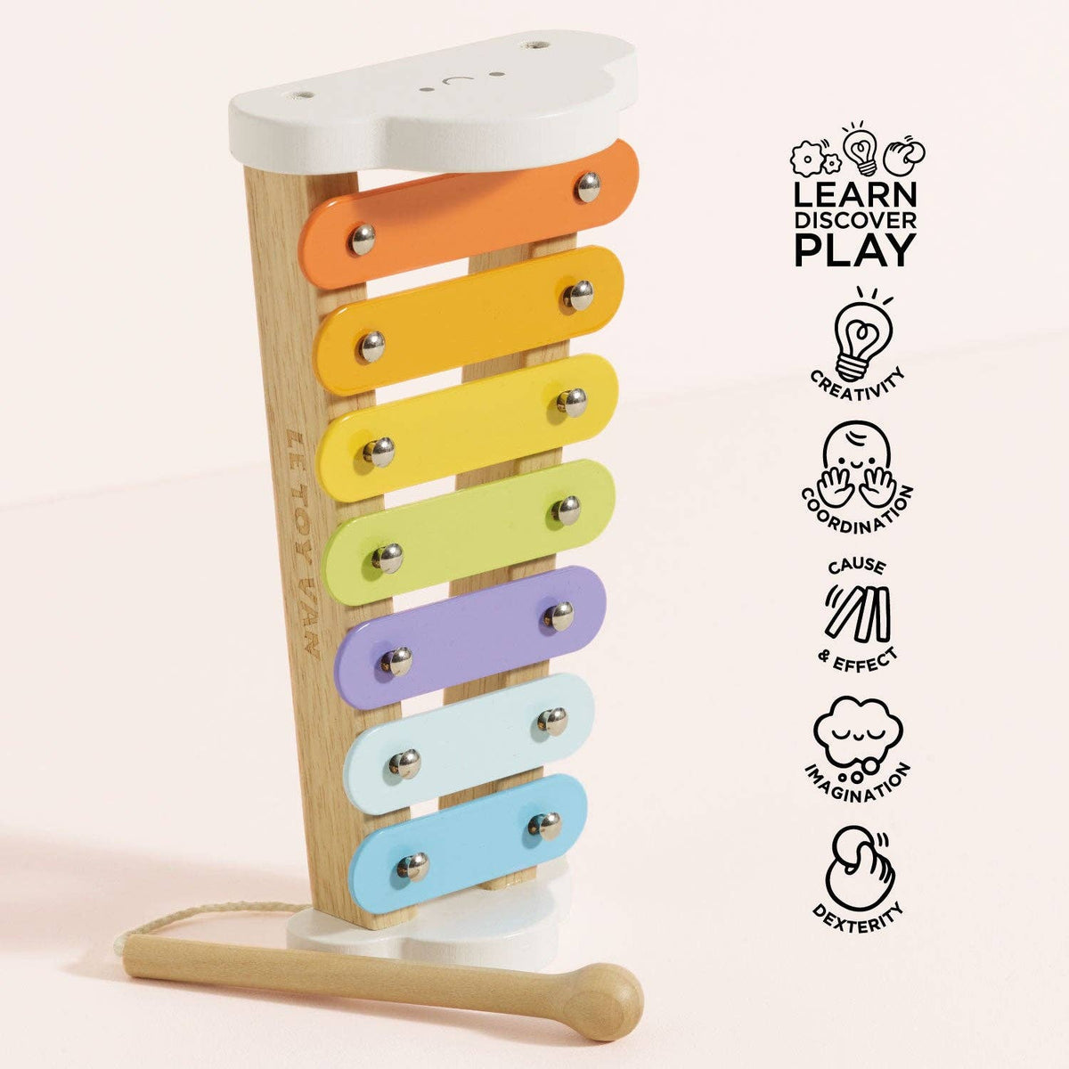 Colorful wooden xylophone with educational icons on a light pink background