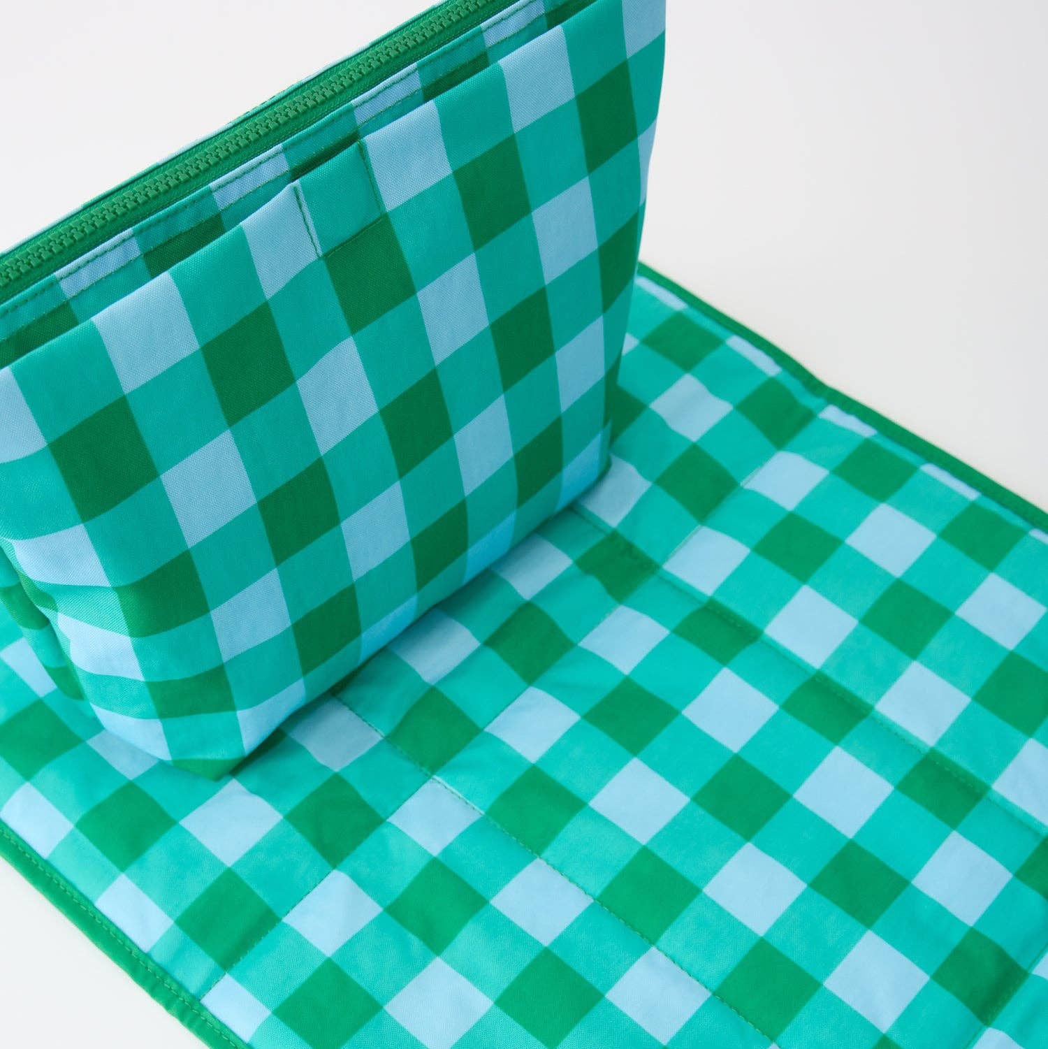 A green and light blue gingham check  pouch with a zipper closure and carrying loop, shown on a plain white background.