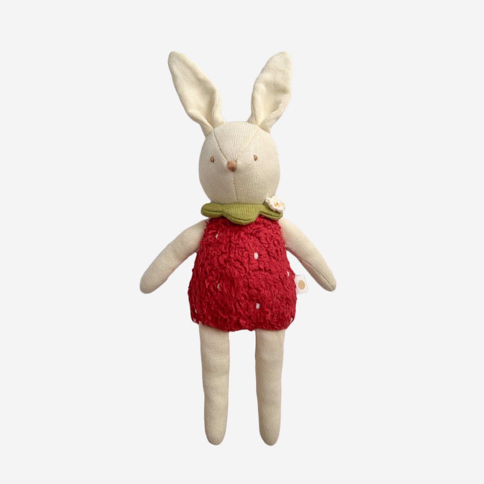 Stuffed bunny toy wearing a red dress on a white background