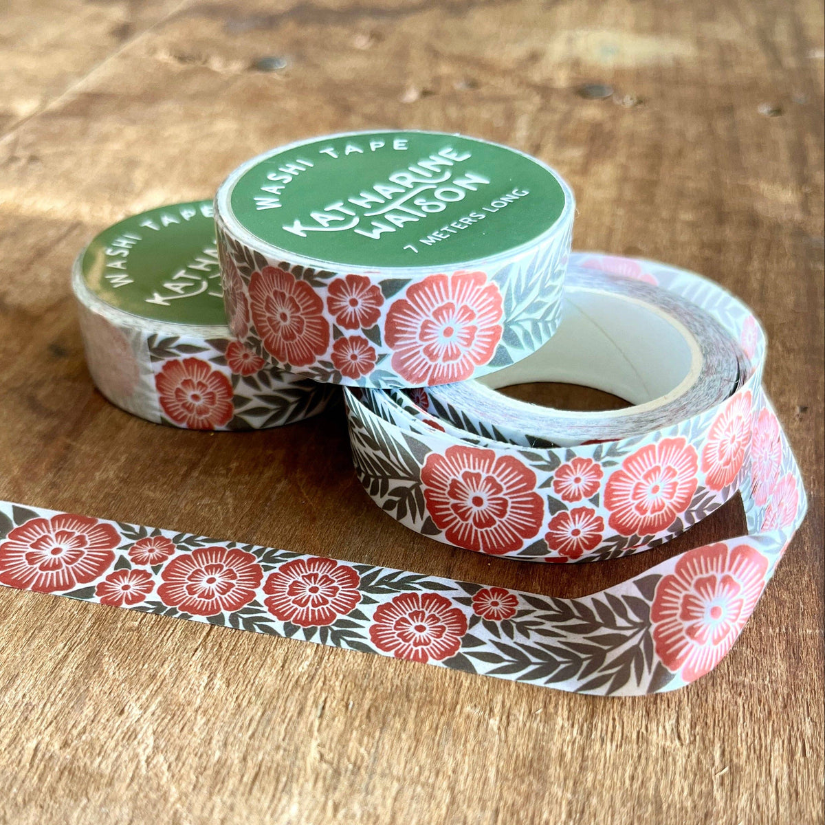 Floral-patterned tape rolls on a wooden surface