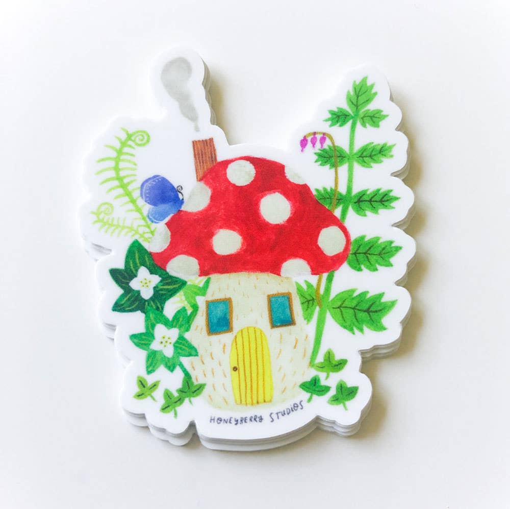 Colorful mushroom-shaped house sticker with greenery on a white background