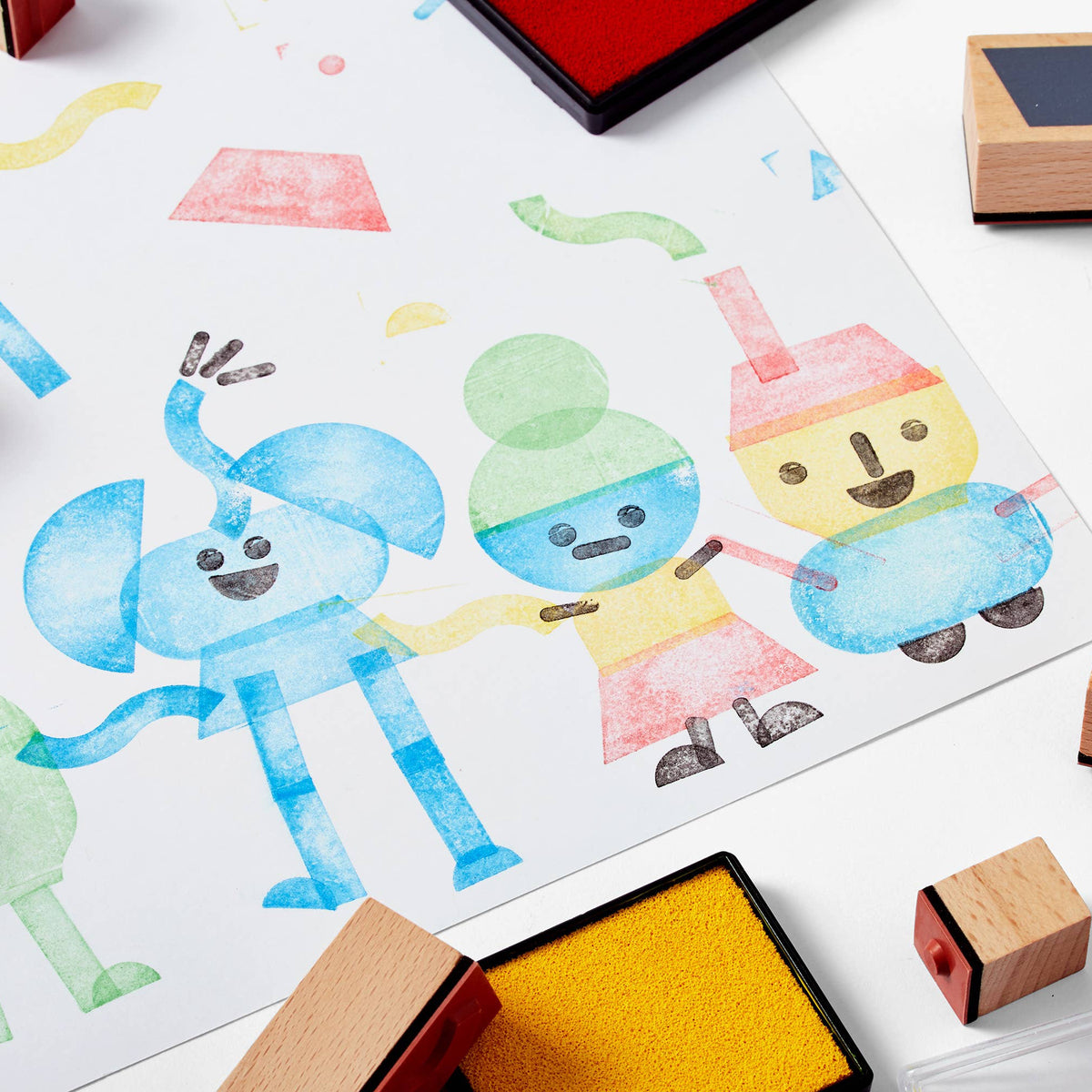 Colorful rubber stamps and ink pads on a white surface