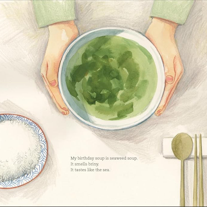 Book cover of 'A Spoonful of the Sea' by Hyewon Yum, featuring an illustration of a child holding a bowl with a seascape.