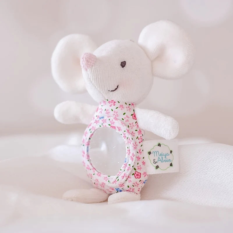 White plush mouse toy with floral rattle on a soft white background