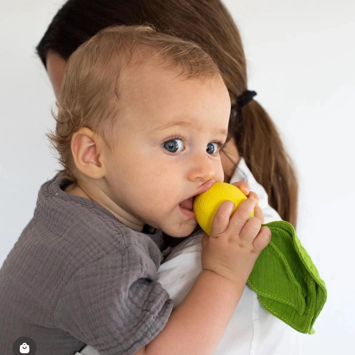 Green leaf-shaped toy with a yellow base on a white background