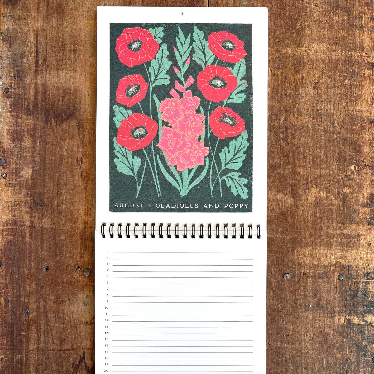 Notebook with floral design on the cover, placed on a wooden surface
