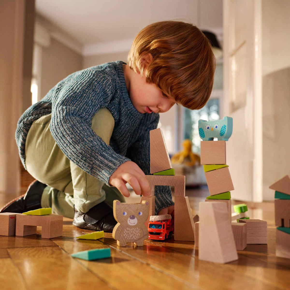 Child playing with wooden blocks on a wooden floor