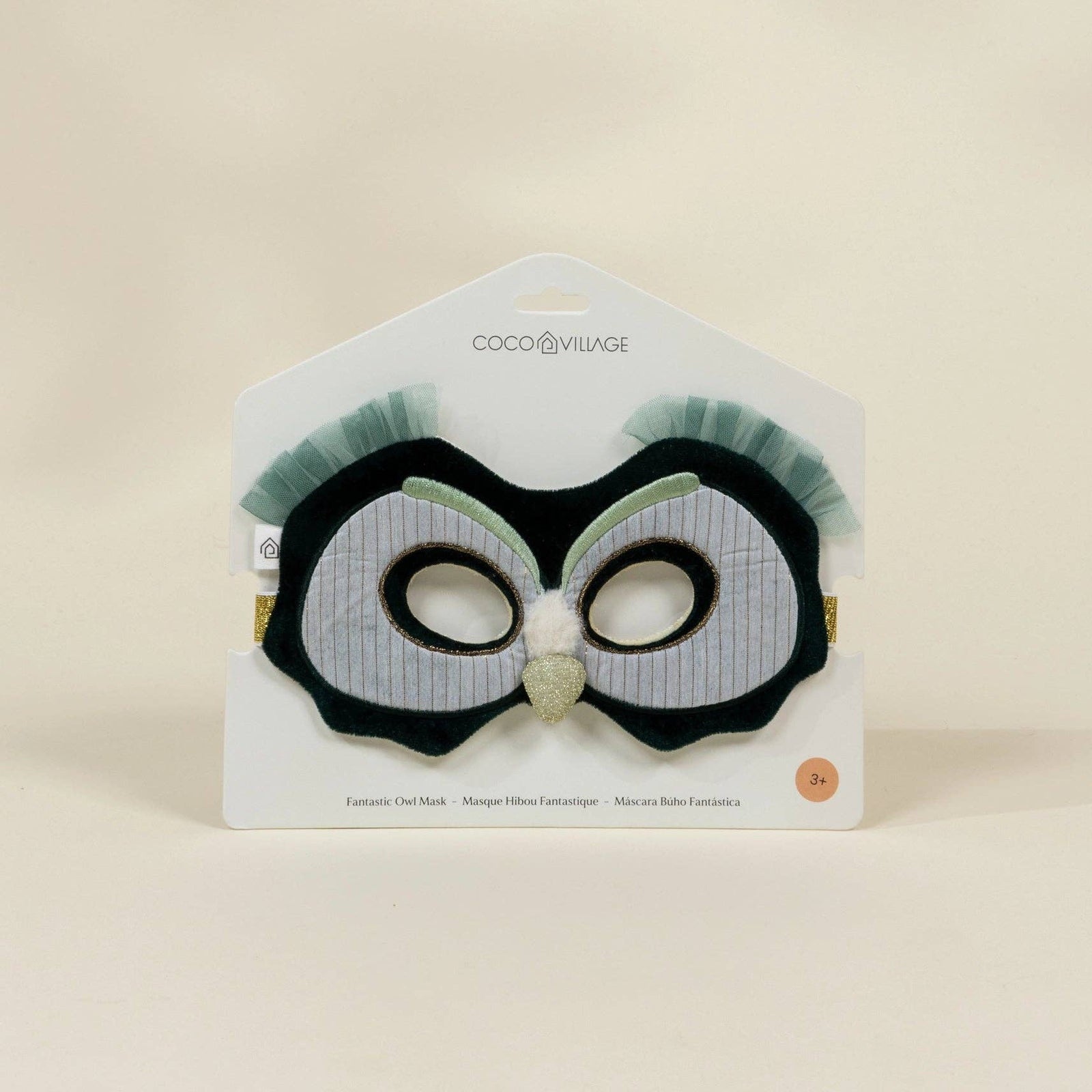 Black and white owl-themed mask on a beige background