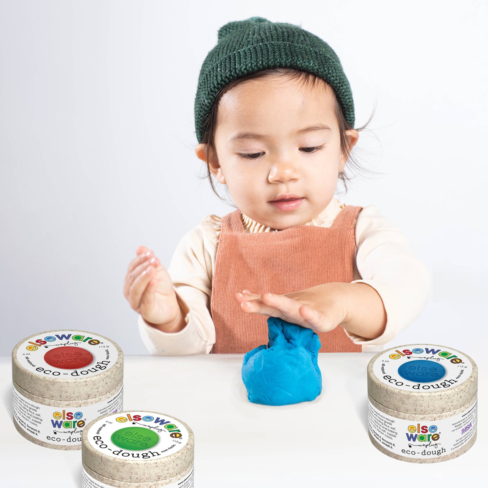 Set of eco-dough containers with colorful labels and a packaging tube labeled 'elseware' on a white background.