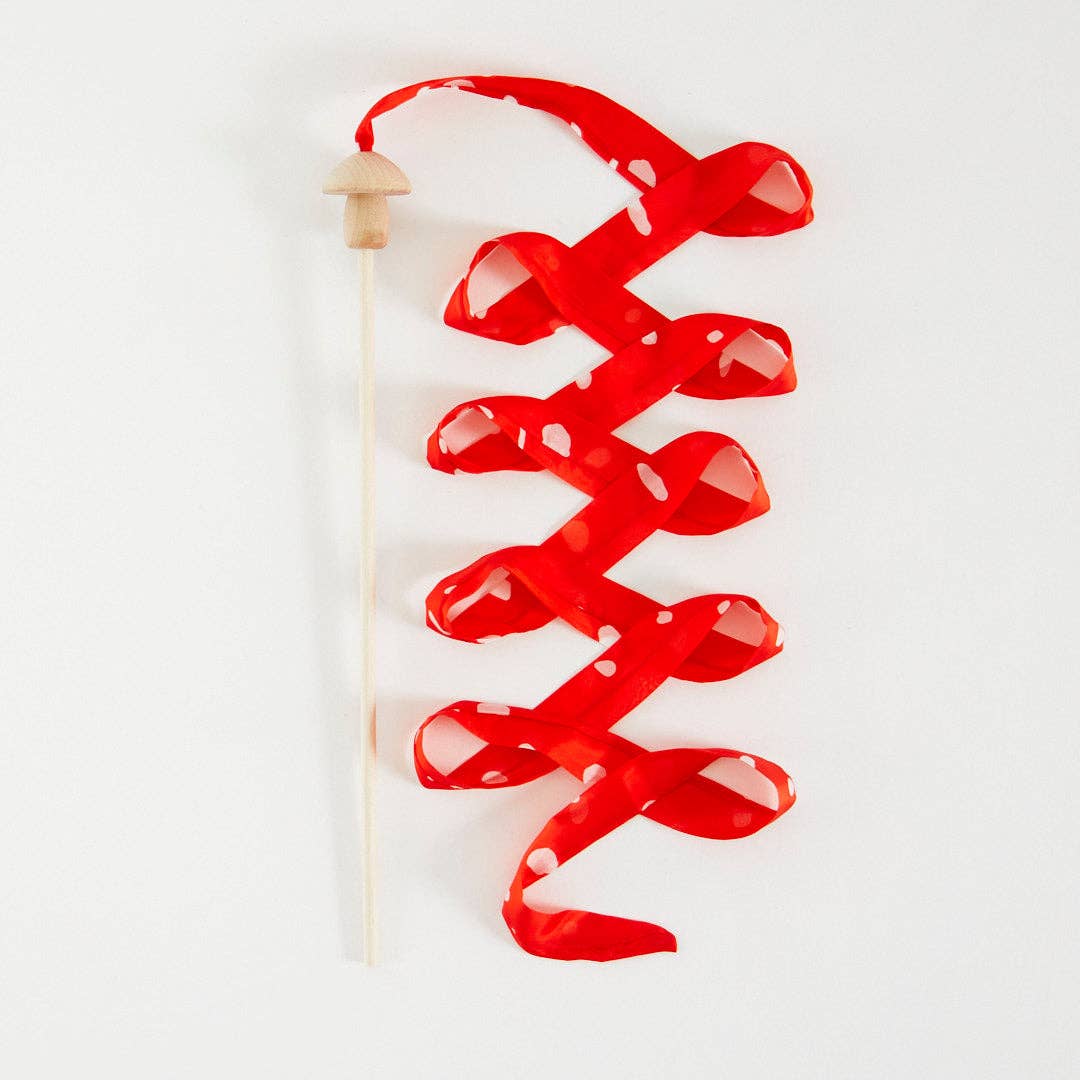 Red silk streamer with wooden mushroom handle on a white background