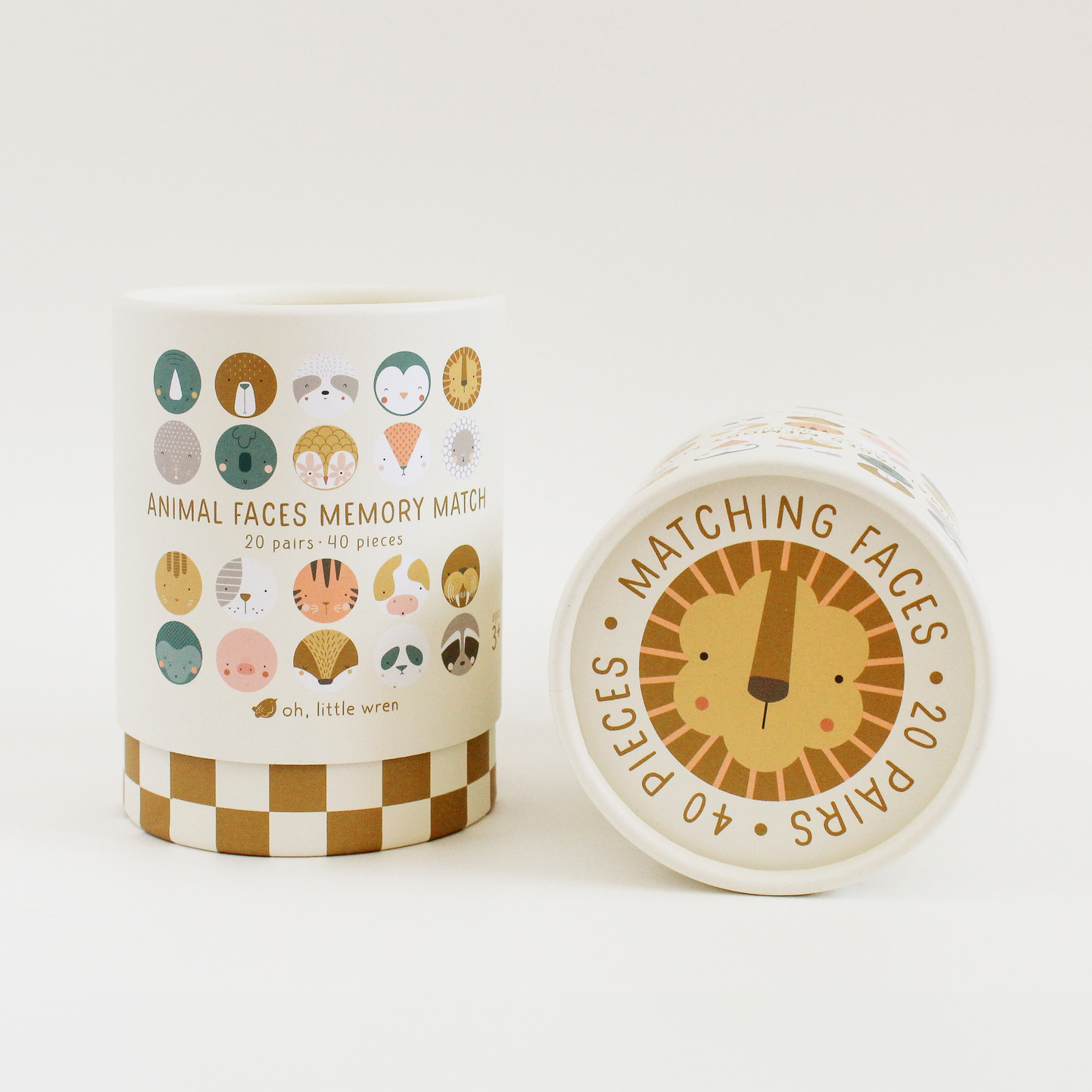Children's memory game with animal face cards, storage canisters, and checkered mat on a white background