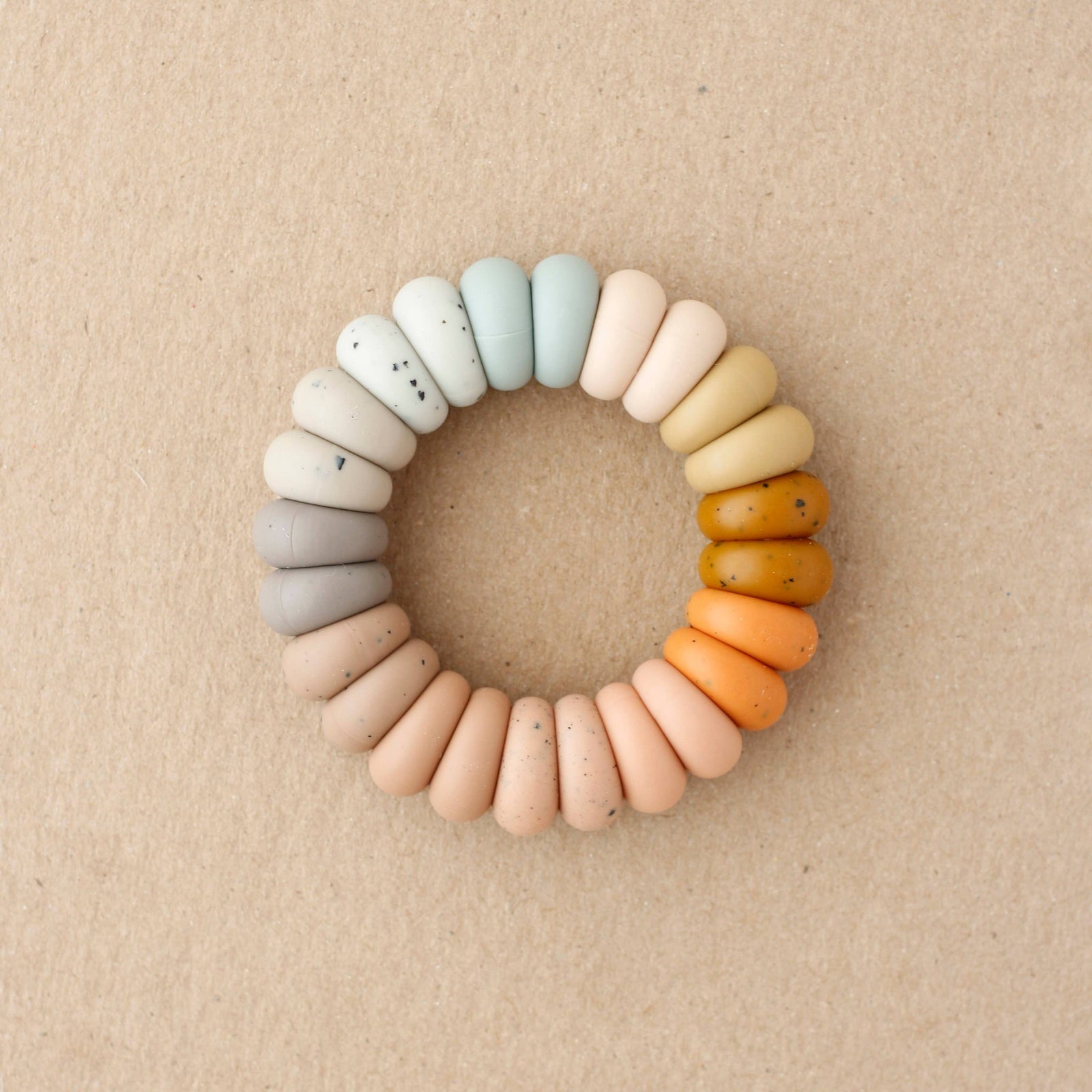 Colorful teething ring on a beige background