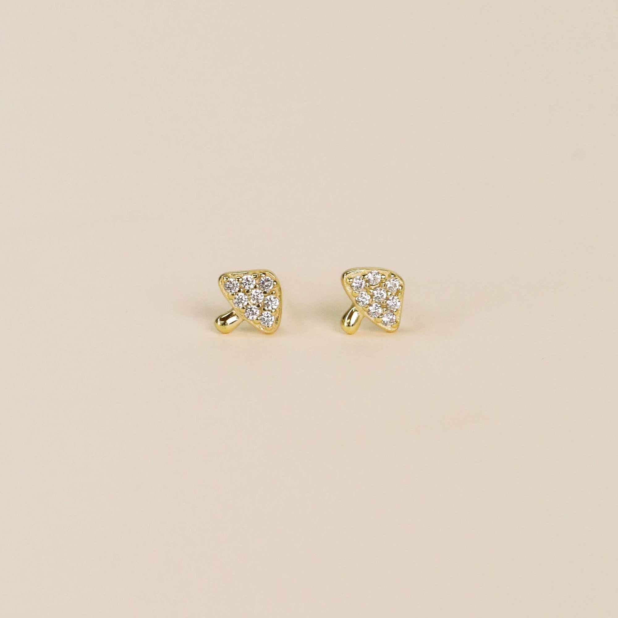 Gold mushroom-shaped earrings on a white background