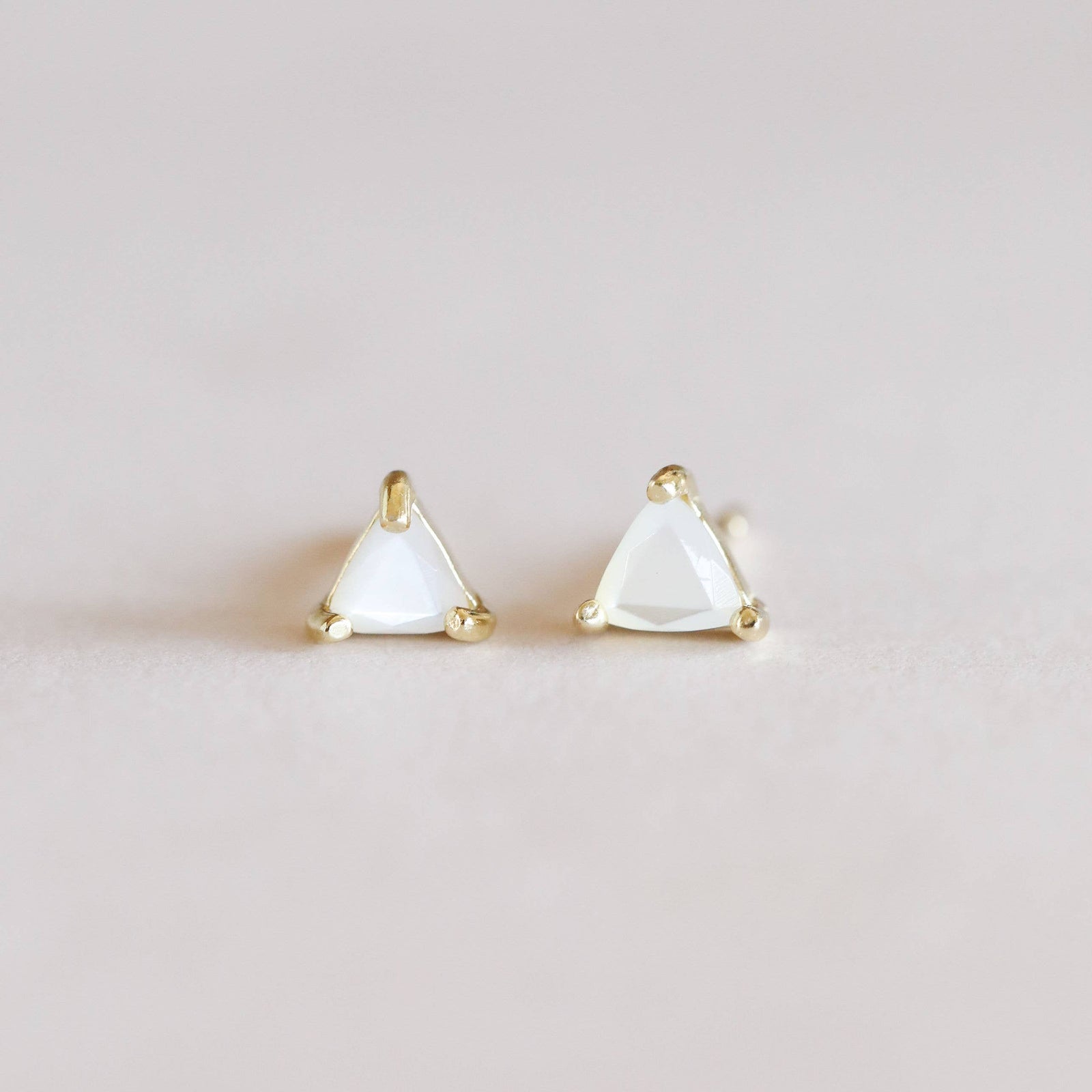 Pair of triangle-shaped earrings on a light gray background
