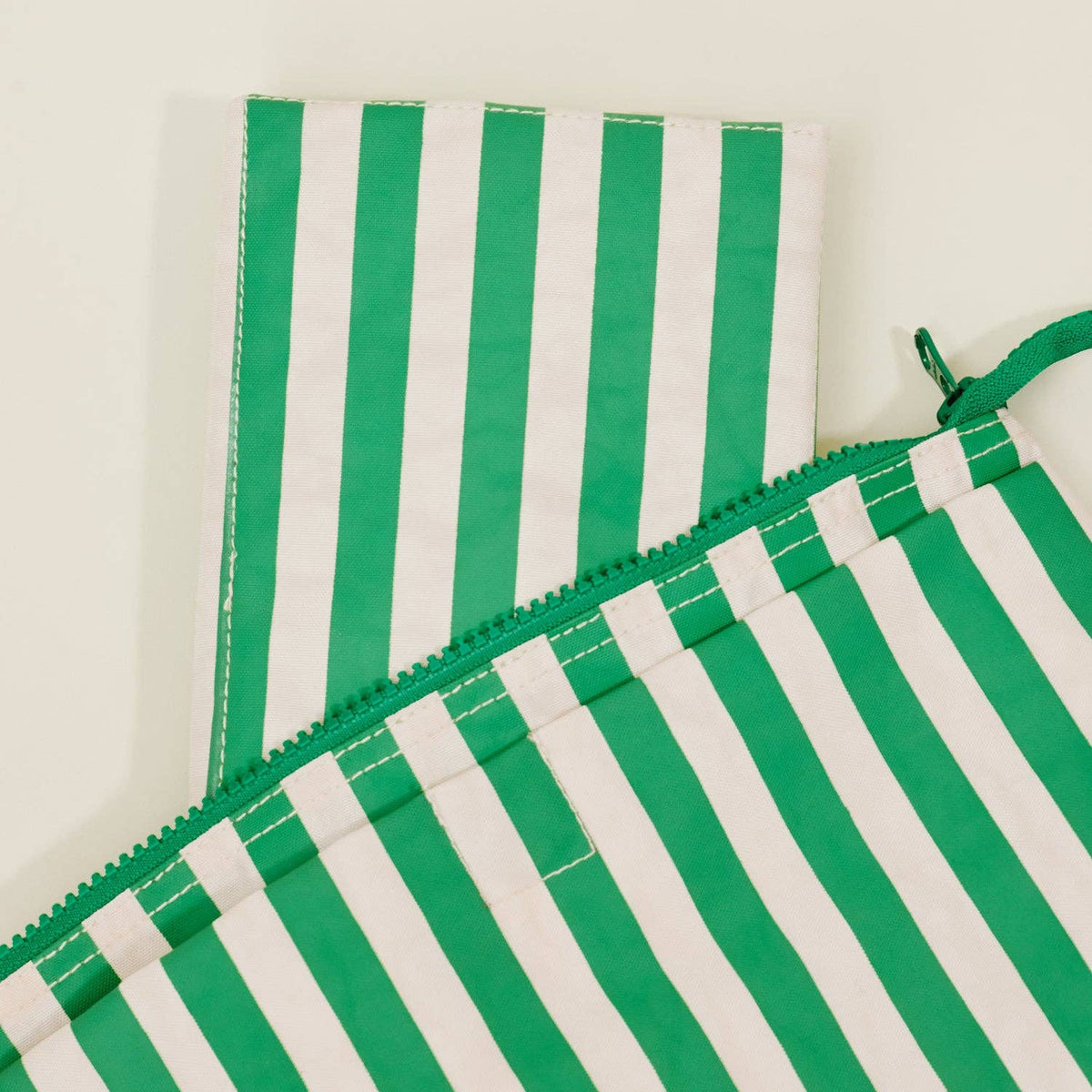 Green and white striped fabric on a beige background