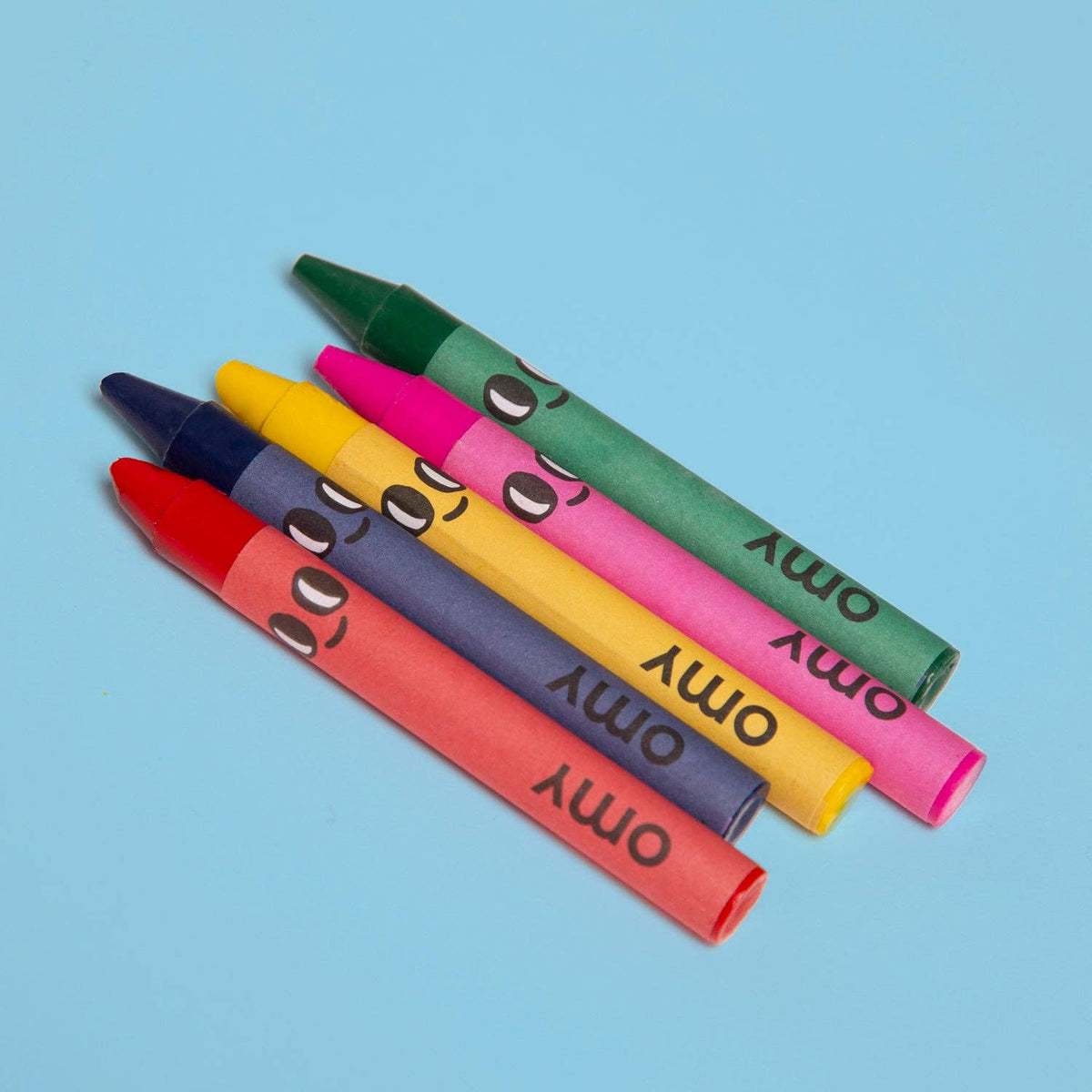 Colorful crayons with cartoon faces on a blue background