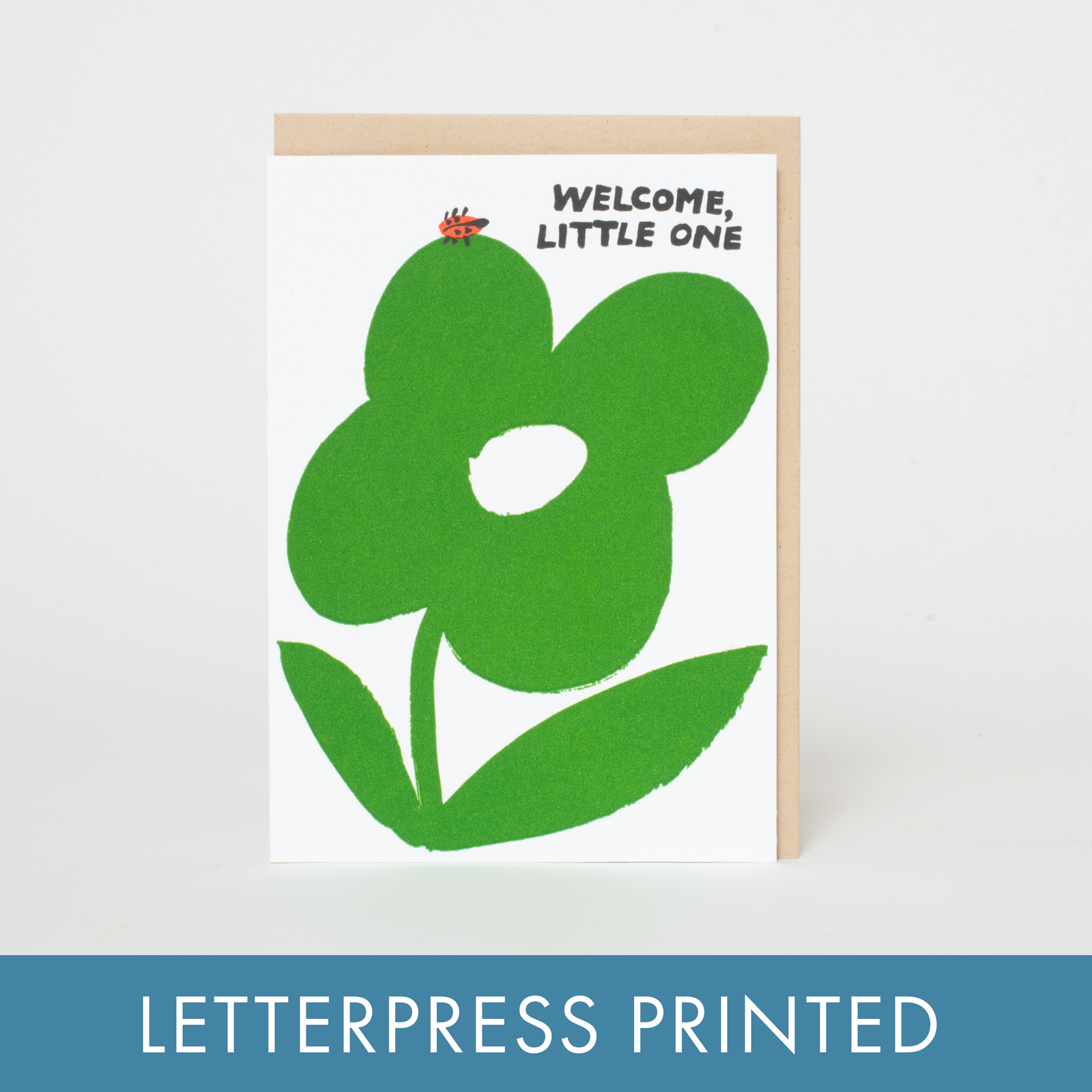 A greeting card with a green floral design and the text 'WELCOME, LITTLE ONE' on it.