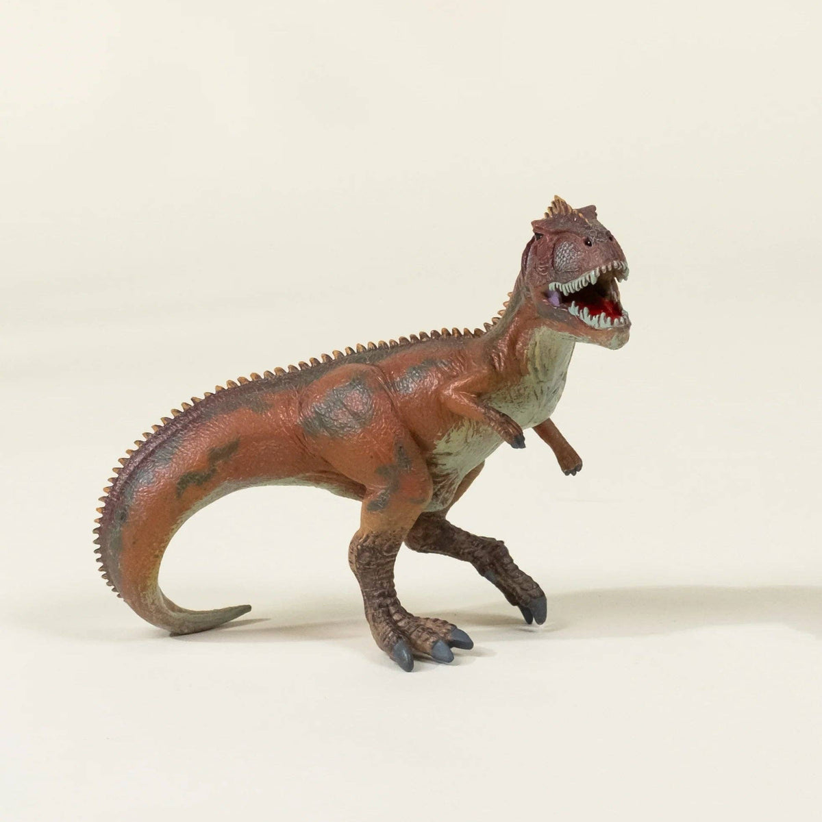 Toy dinosaur figure on a beige background