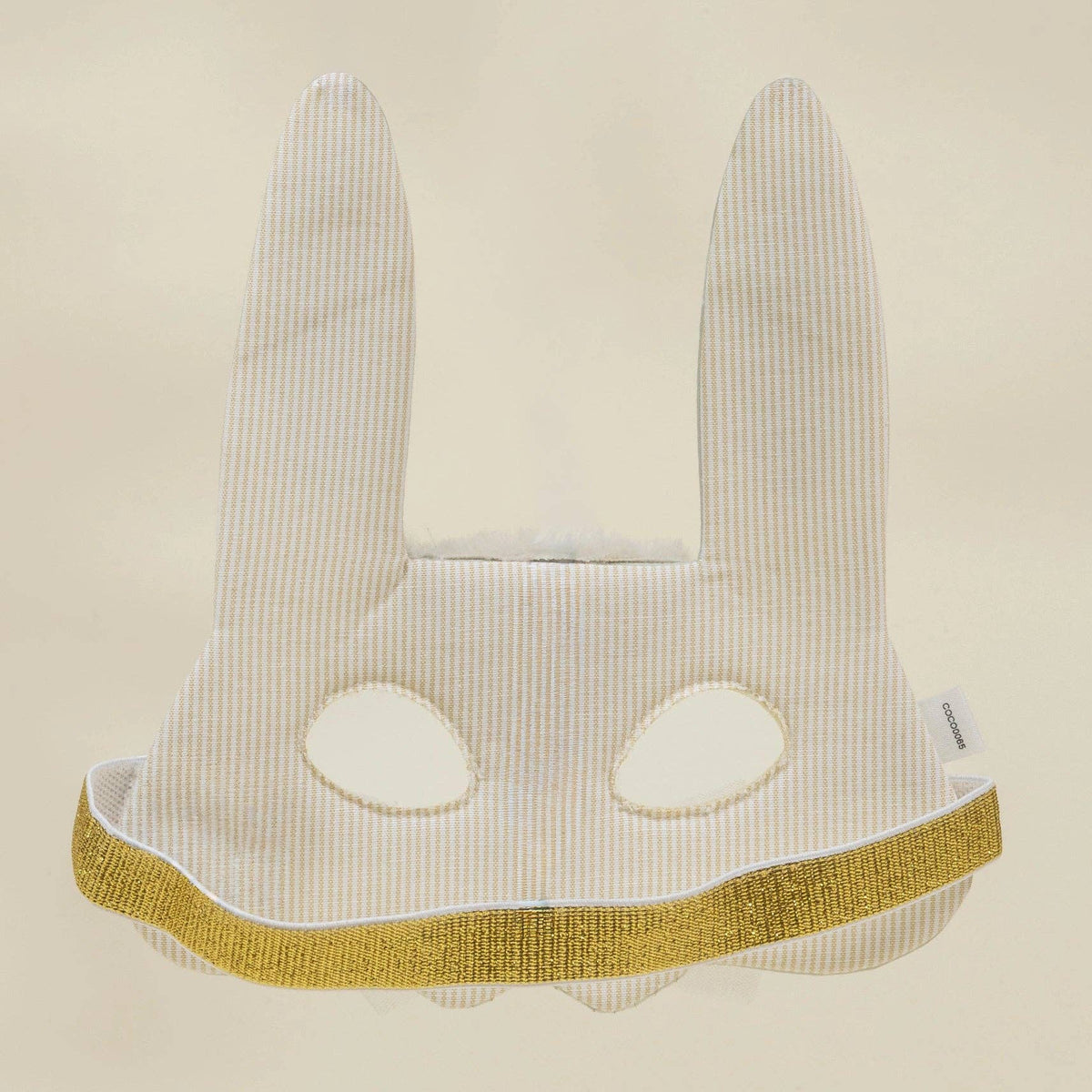 Bunny-shaped mask with long ears and a yellow band on a beige background