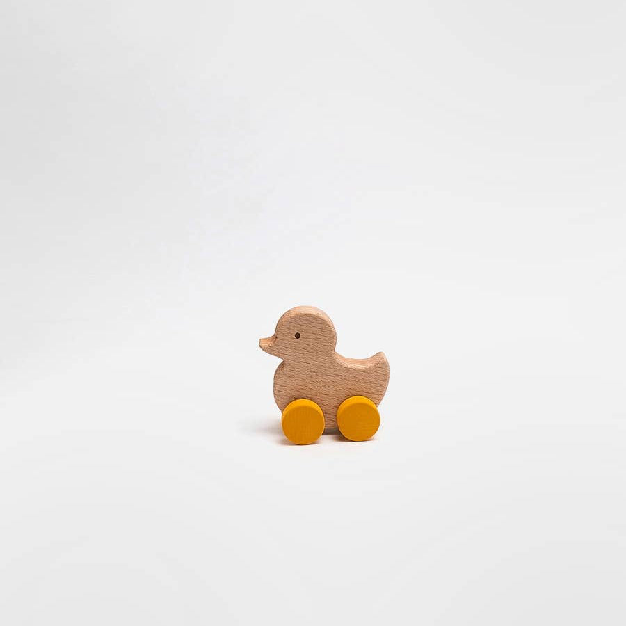 Wooden duck toy with yellow wheels on a white background