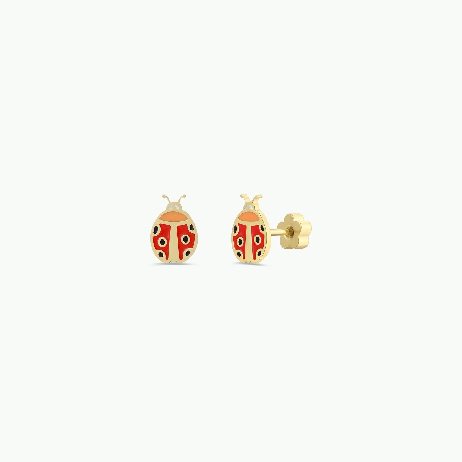 Gold ladybug earrings on a white background