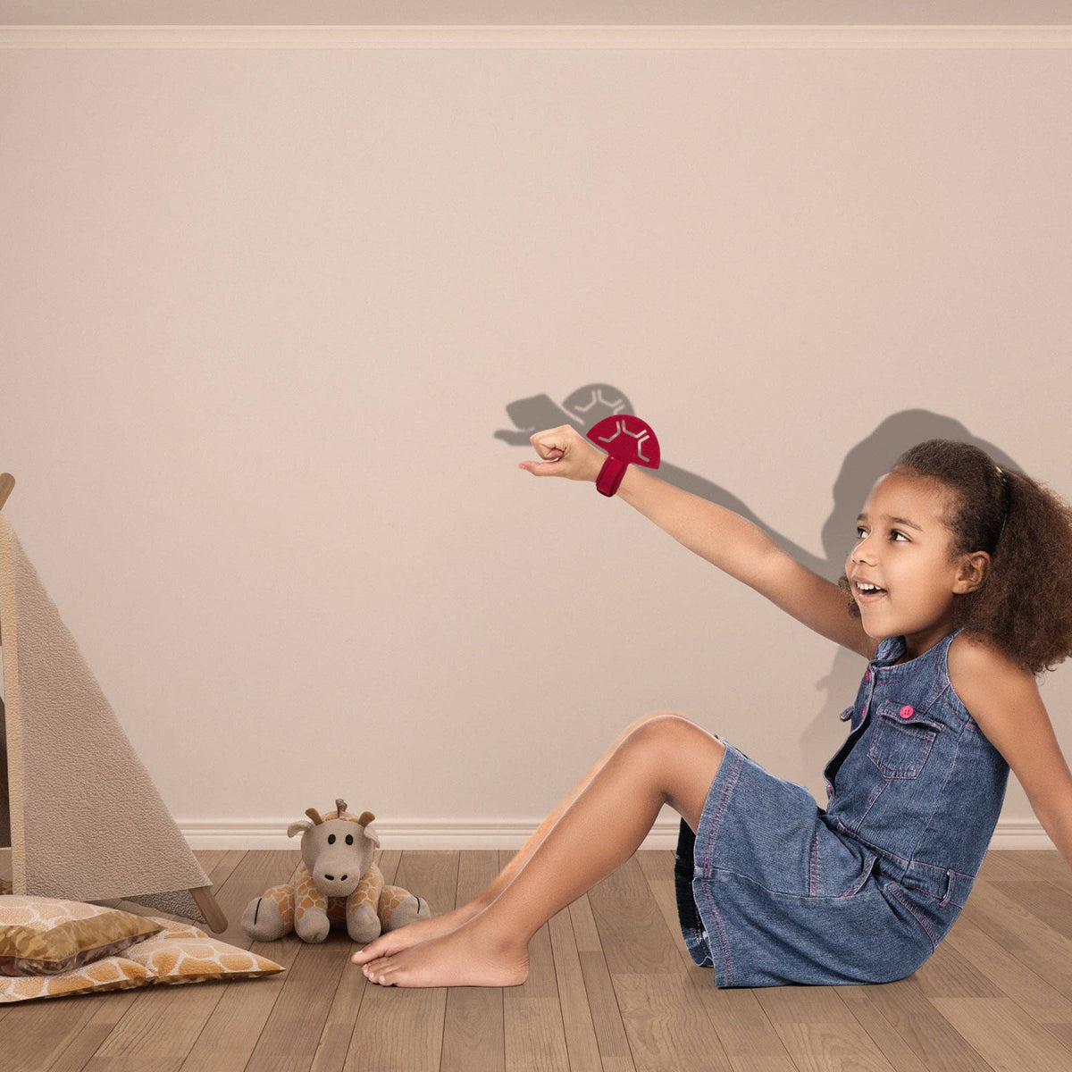 Child playing with a toy in a room with a wooden floor and beige walls.