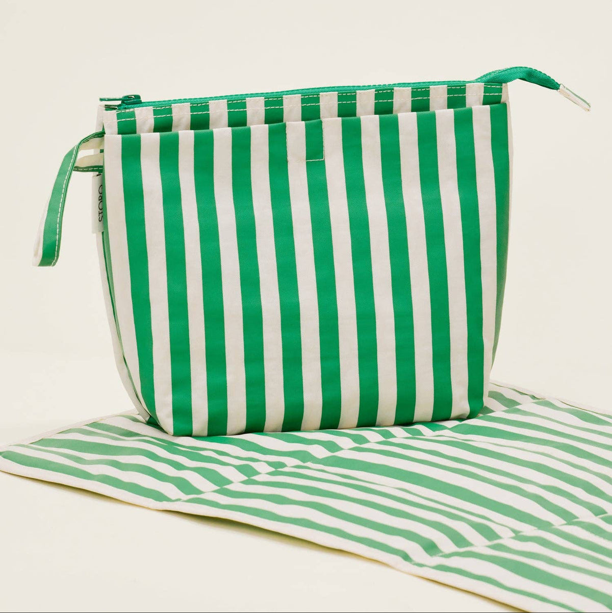 Green and white striped bag on a matching green and white striped mat.