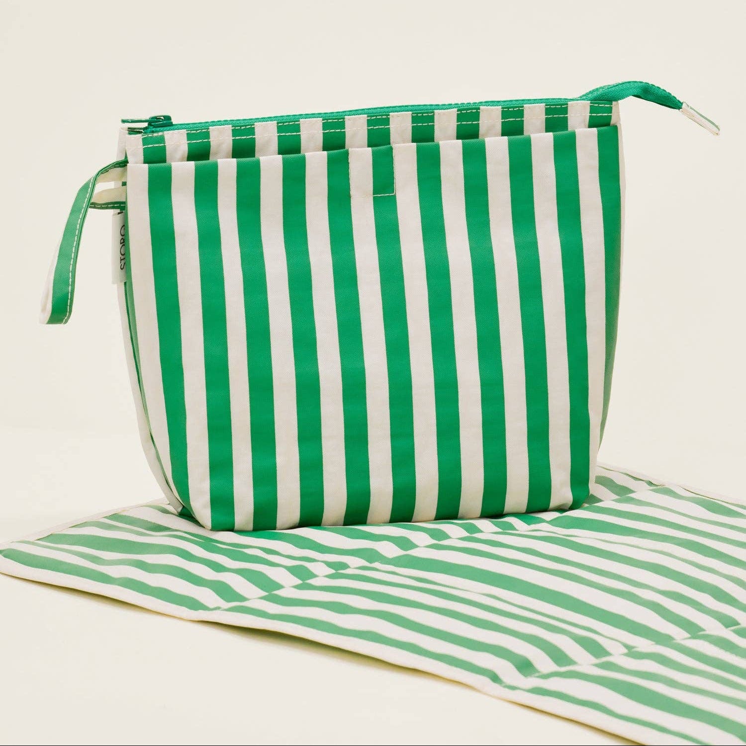 Green and white striped bag on a beige background