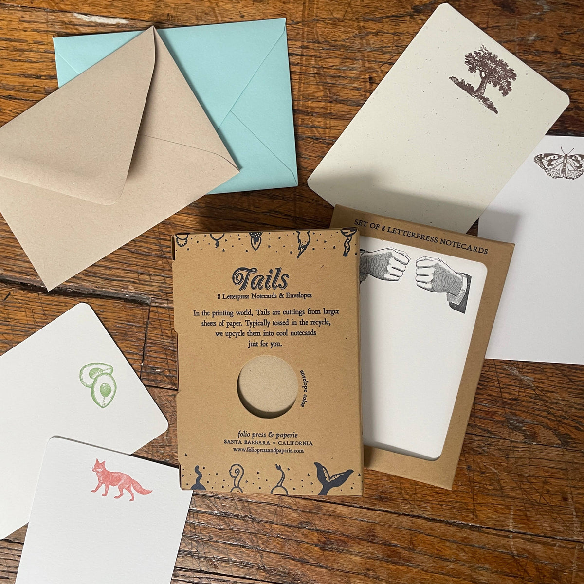 Collection of letterpress notecards and envelopes on a wooden surface